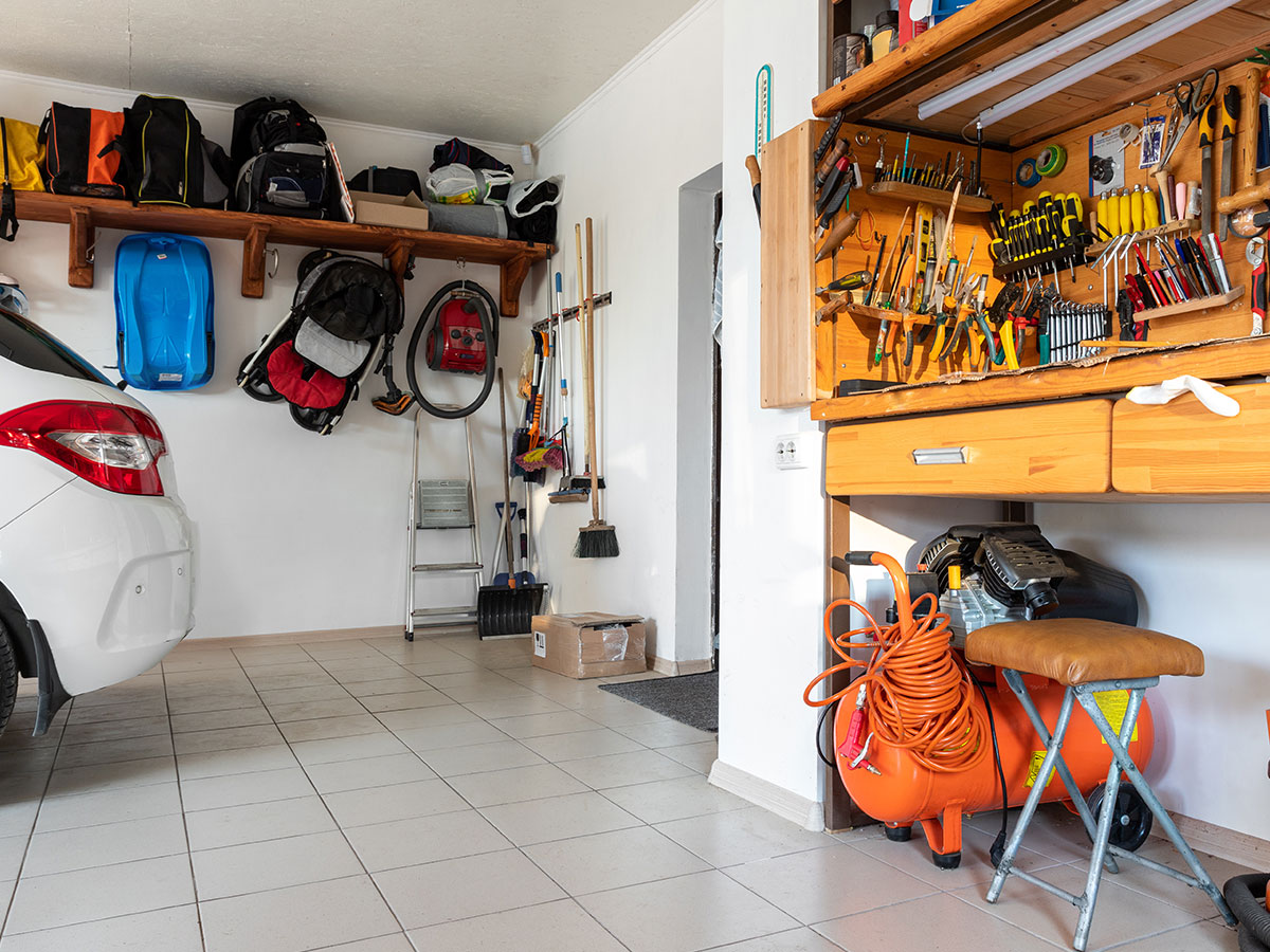 garage con mensole in legno e angolo con attrezzature da lavoro