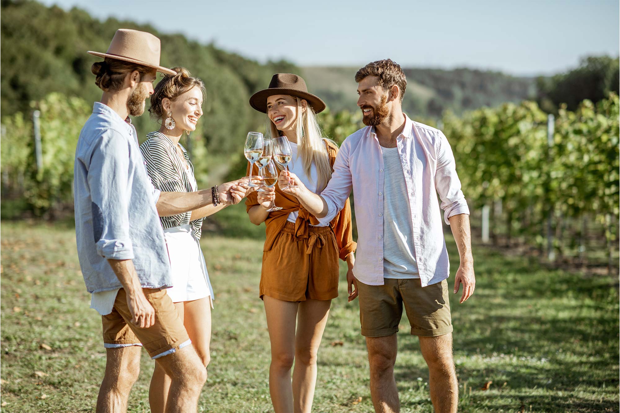coppia di amici brinda in mezzo a un vigneto