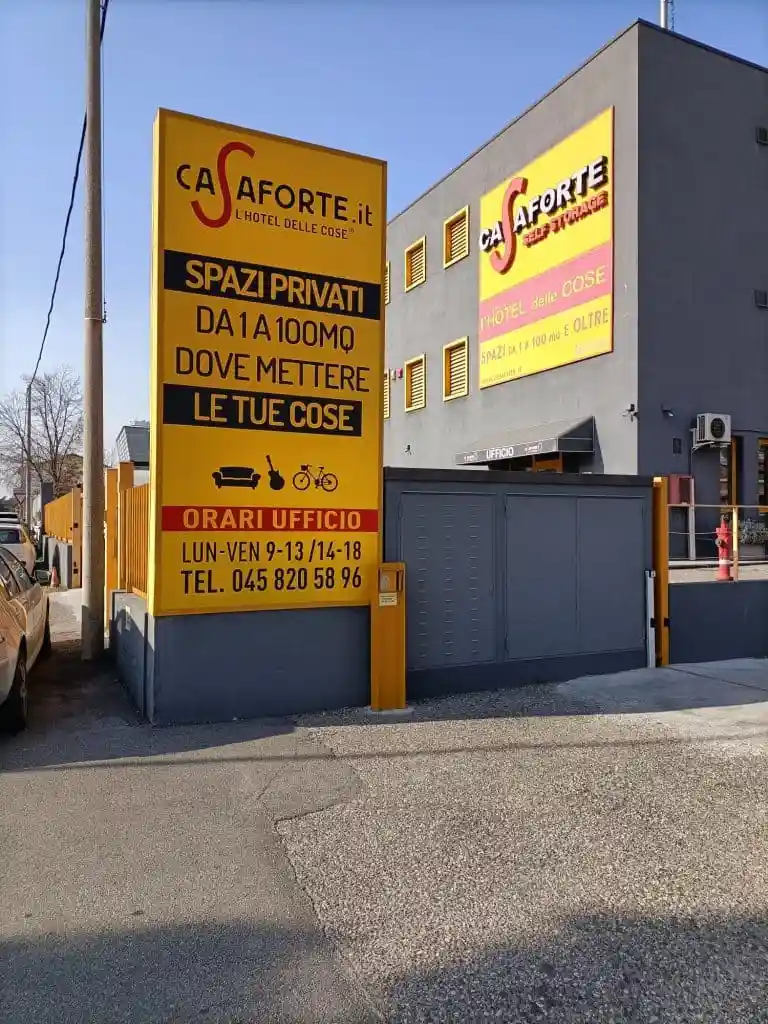 cartellone giallo davanti a ingresso di un edificio grigio