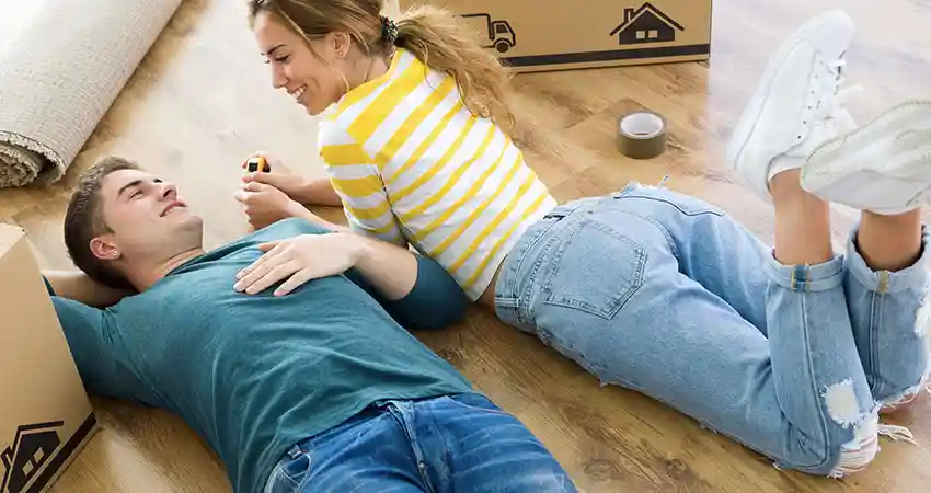 coppia sorridente sdraiata sul pavimento